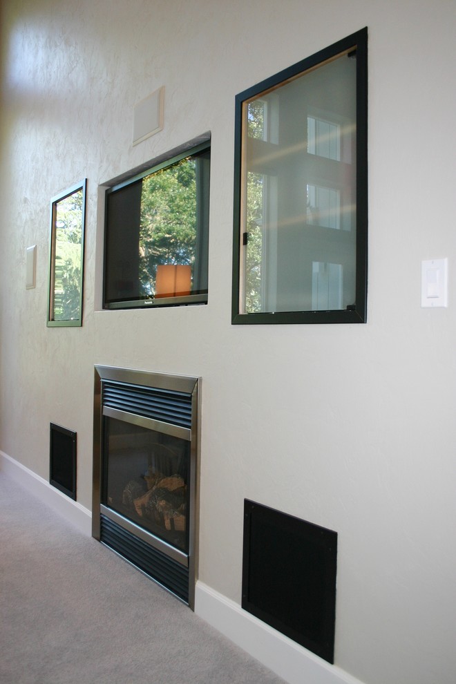 This is an example of a mid-sized modern open concept family room in Portland with beige walls, carpet, a standard fireplace and a built-in media wall.