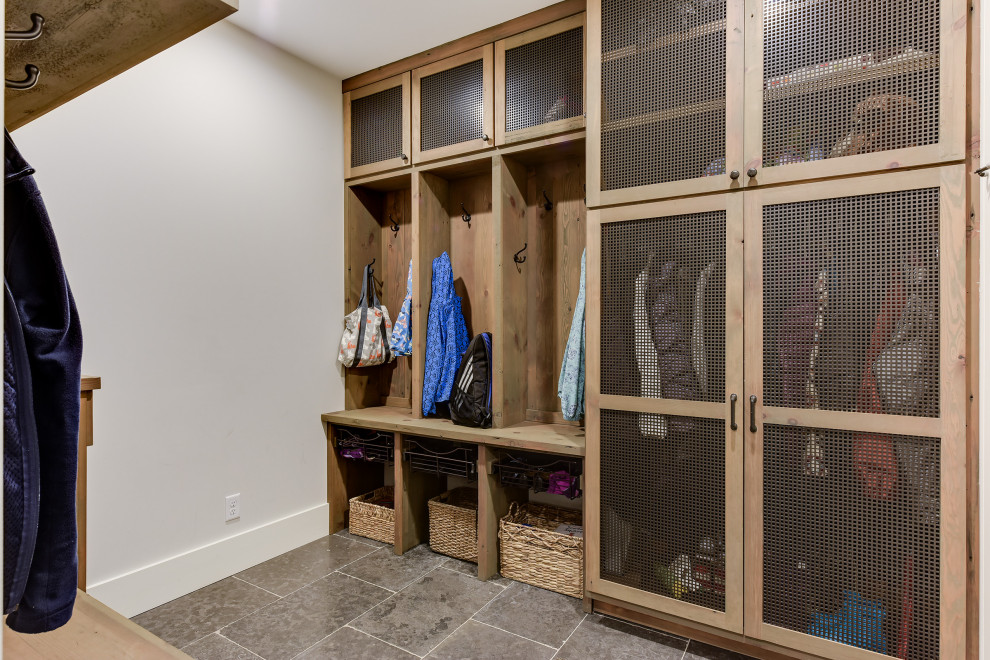 This is an example of a mid-sized country mudroom in Minneapolis with white walls, limestone floors, a single front door, a medium wood front door and blue floor.