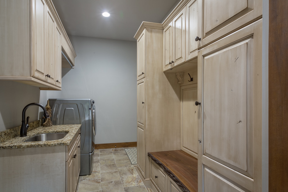 Design ideas for a large country galley utility room in Charlotte with an undermount sink, raised-panel cabinets, light wood cabinets, granite benchtops, grey walls, ceramic floors, a side-by-side washer and dryer and beige floor.