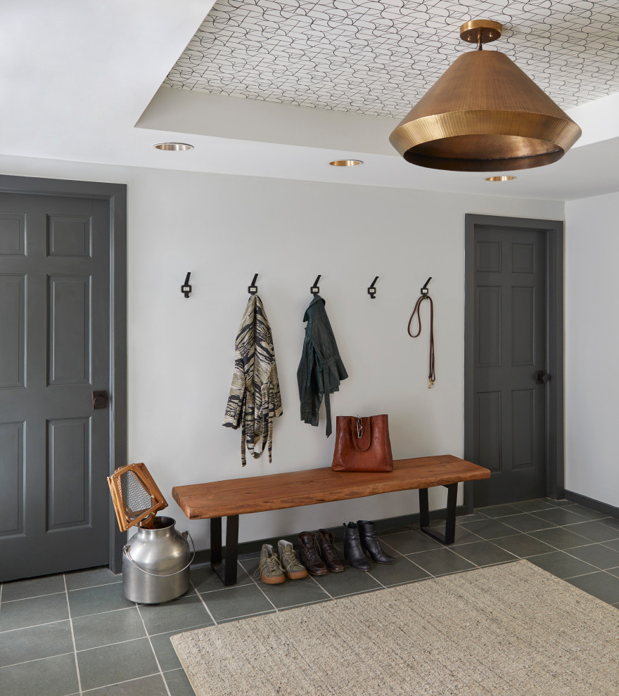 Photo of a country foyer in New York with grey walls, slate floors, grey floor and wallpaper.