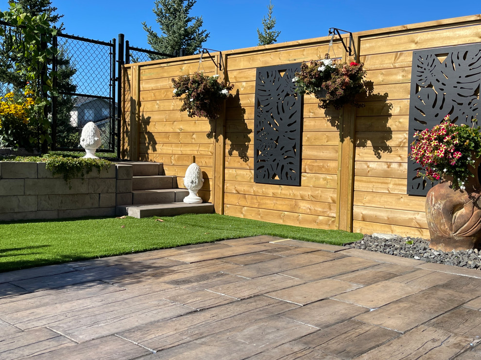 Design ideas for a mid-sized drought-tolerant and full sun backyard brick and wood fence landscaping in Edmonton for summer.