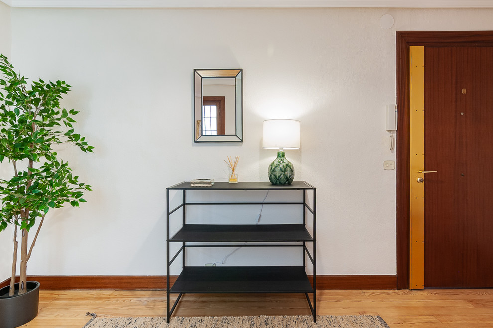 Imagen de entrada clásica renovada con suelo de madera en tonos medios