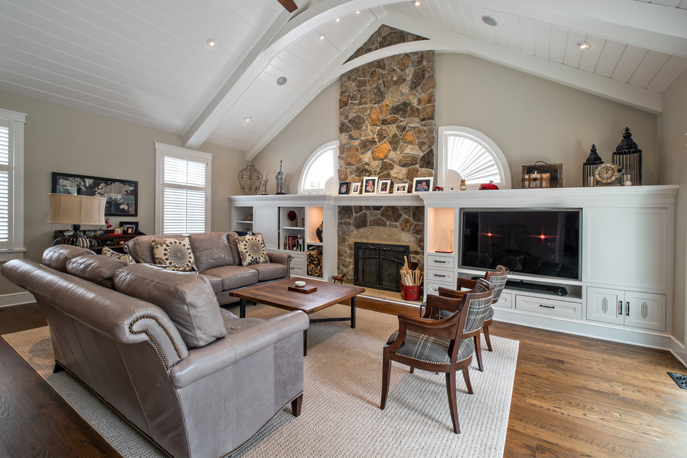 Photo of a large traditional open concept family room in Grand Rapids with a music area, brown walls, light hardwood floors, a standard fireplace, a stone fireplace surround and a built-in media wall.