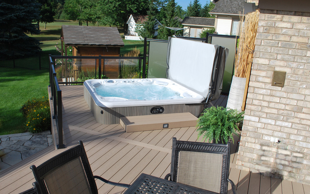 Design ideas for a mid-sized traditional backyard aboveground pool in Toronto with a hot tub.
