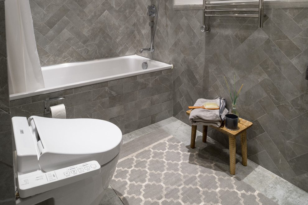 Mid-sized beach style master bathroom in Other with louvered cabinets, dark wood cabinets, an alcove tub, a one-piece toilet, gray tile, matchstick tile, white walls, concrete floors, a drop-in sink and grey floor.
