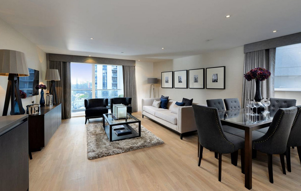 Inspiration for a medium sized modern formal open plan living room in London with beige walls, light hardwood flooring, no fireplace and a freestanding tv.