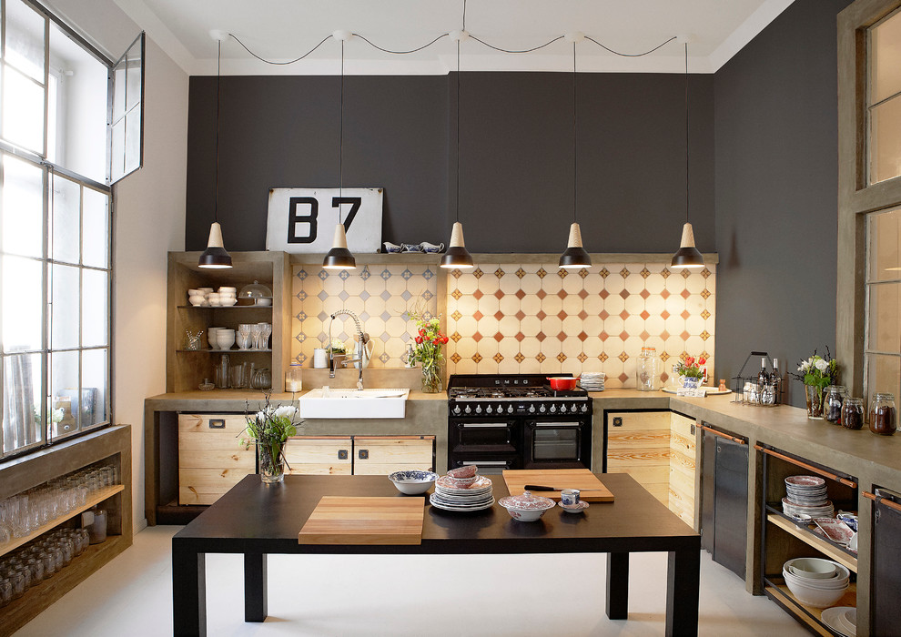 Design ideas for a large industrial u-shaped separate kitchen in Berlin with concrete benchtops, multi-coloured splashback, mosaic tile splashback, a farmhouse sink, medium wood cabinets, black appliances and with island.