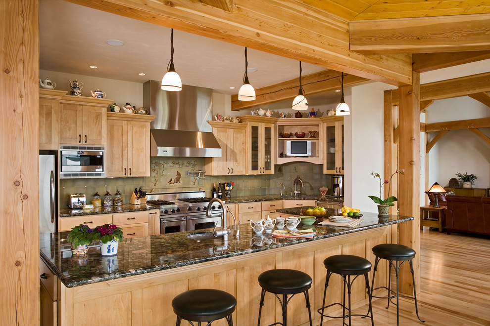 This is an example of a large country l-shaped kitchen in Seattle with an undermount sink, shaker cabinets, green splashback, stainless steel appliances, medium hardwood floors, with island, granite benchtops, light wood cabinets and ceramic splashback.