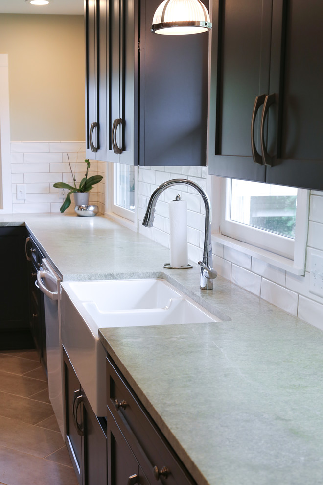 Inspiration for a mid-sized transitional galley separate kitchen in Minneapolis with a farmhouse sink, shaker cabinets, grey cabinets, quartzite benchtops, white splashback, ceramic splashback, stainless steel appliances, ceramic floors and no island.