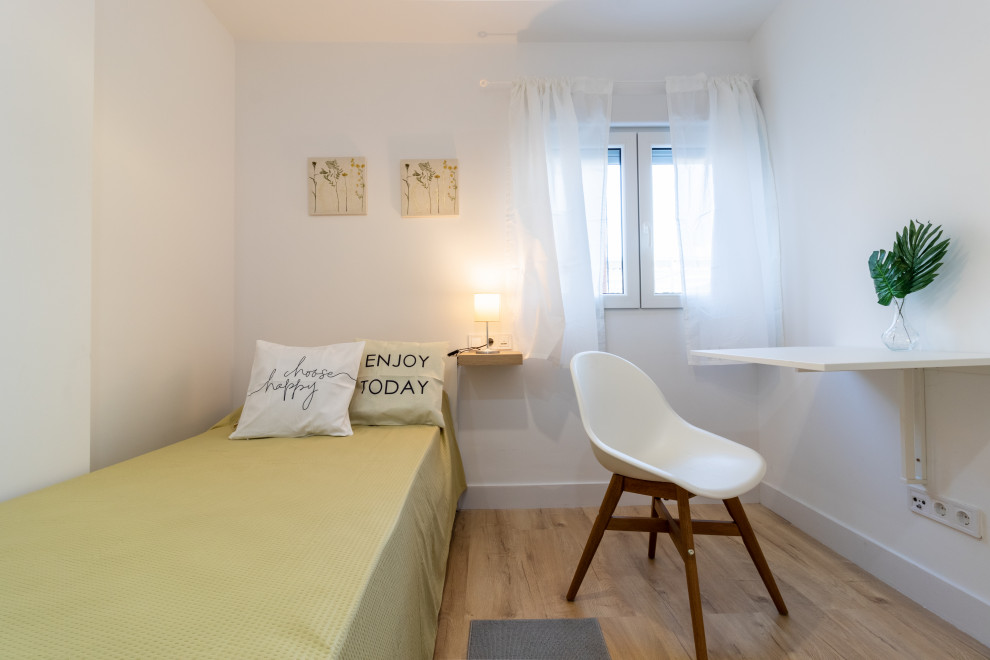Cette image montre une chambre d'amis blanche et bois nordique avec un mur blanc, parquet clair et un sol marron.