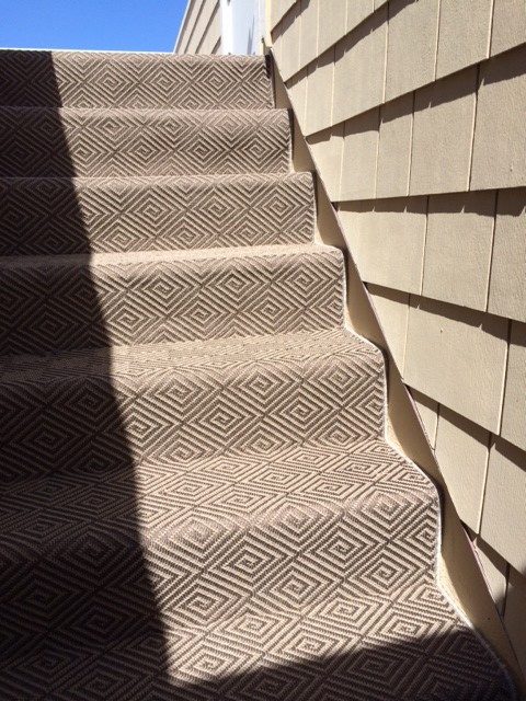 This is an example of a mid-sized beach style carpeted straight staircase in Orange County with carpet risers.