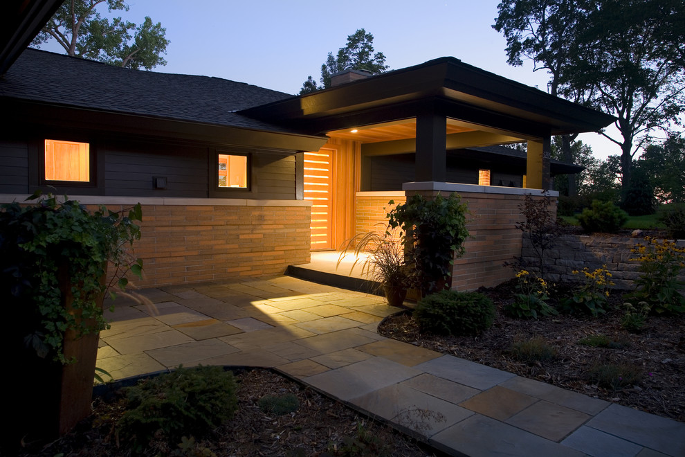 Photo of a large midcentury one-storey black exterior in Minneapolis with mixed siding and a hip roof.