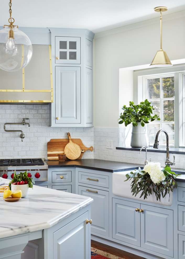 This is an example of a small traditional u-shaped separate kitchen in Minneapolis with a farmhouse sink, blue cabinets, white splashback, ceramic splashback, panelled appliances, dark hardwood floors and with island.