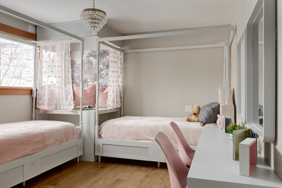 This is an example of a transitional kids' bedroom for girls in Calgary with beige walls, medium hardwood floors and brown floor.