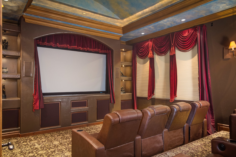 Photo of a large mediterranean enclosed home theatre in Orange County with brown walls, carpet and a projector screen.