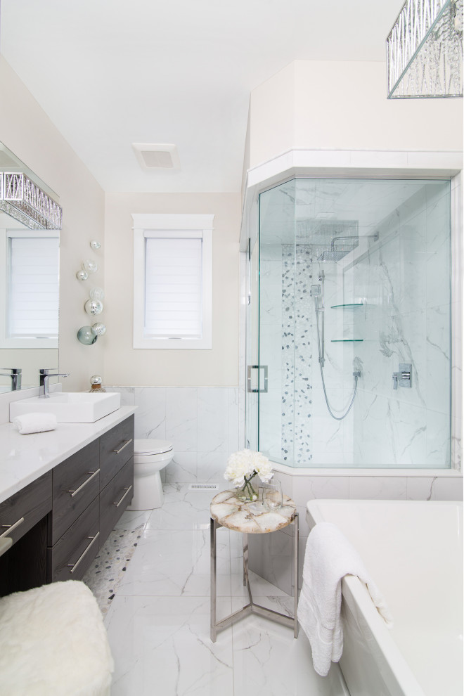 Transitional master white tile white floor corner shower photo with flat-panel cabinets, gray cabinets, beige walls, a vessel sink, a hinged shower door, white countertops and a floating vanity