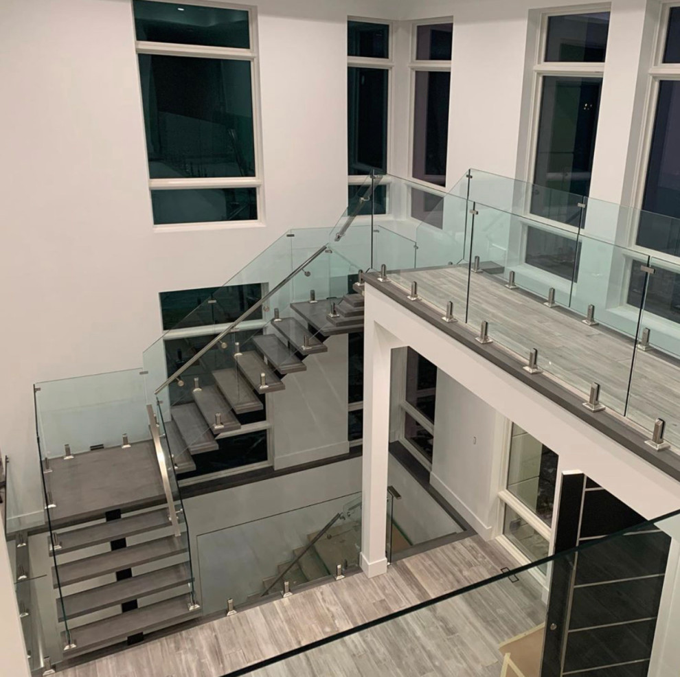 Design ideas for a modern staircase in Toronto with glass railing.
