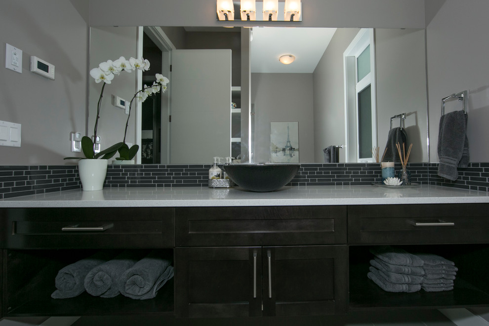 Inspiration for a mid-sized contemporary bathroom in Edmonton with a drop-in sink, recessed-panel cabinets, dark wood cabinets, gray tile, ceramic tile, grey walls, ceramic floors and a one-piece toilet.
