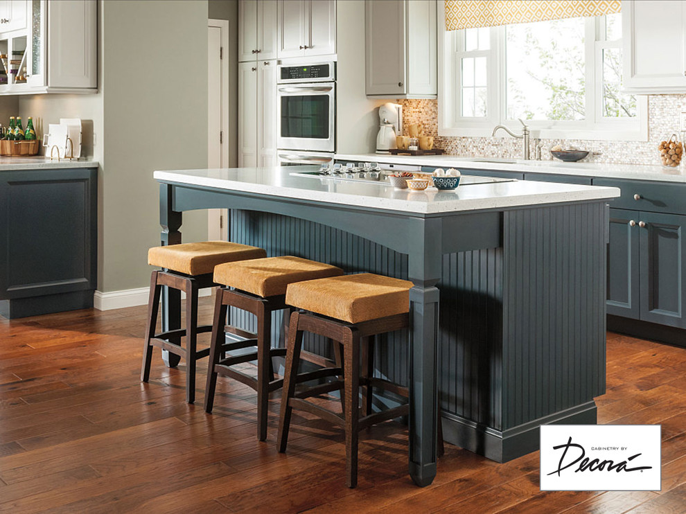Brown floor kitchen photo with blue cabinets and an island