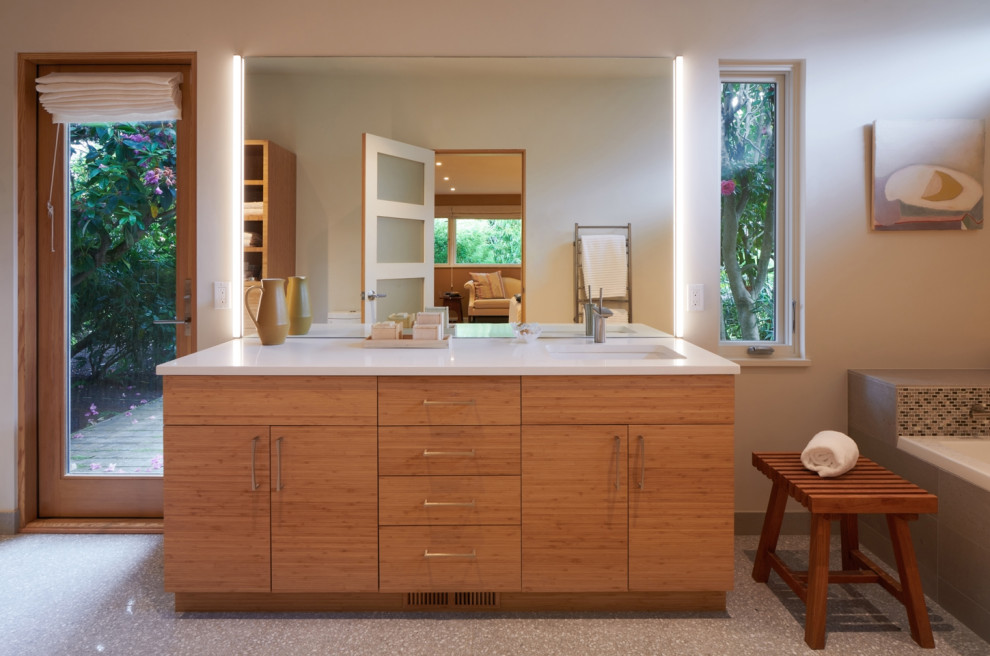Photo of a mid-sized midcentury master wet room bathroom in Seattle with flat-panel cabinets, brown cabinets, a drop-in tub, a bidet, cement tile, white walls, terrazzo floors, an undermount sink, quartzite benchtops, grey floor, a hinged shower door, white benchtops, a single vanity, a freestanding vanity and vaulted.
