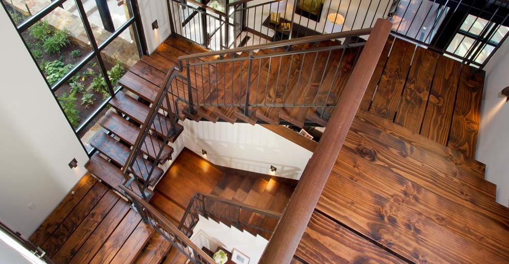 This is an example of a modern wood u-shaped staircase in Denver with open risers.