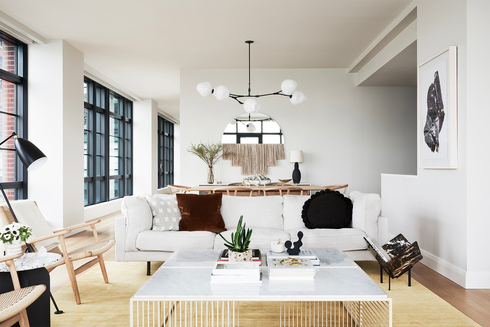 Design ideas for a scandinavian formal open concept living room in New York with white walls and light hardwood floors.