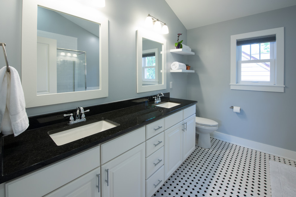 Inspiration for a mid-sized arts and crafts master bathroom in Indianapolis with raised-panel cabinets, black and white tile, porcelain tile, an alcove tub, a corner shower, a two-piece toilet, grey walls, porcelain floors, an undermount sink, white cabinets and granite benchtops.