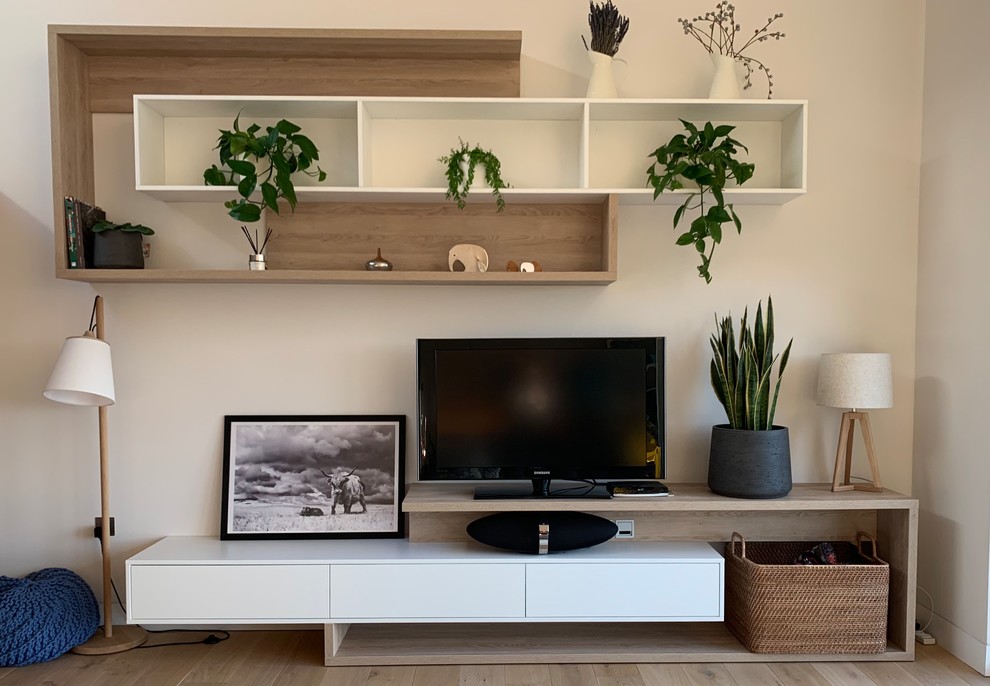 Diseño de salón para visitas nórdico grande con paredes beige, suelo de madera clara, televisor independiente y suelo beige
