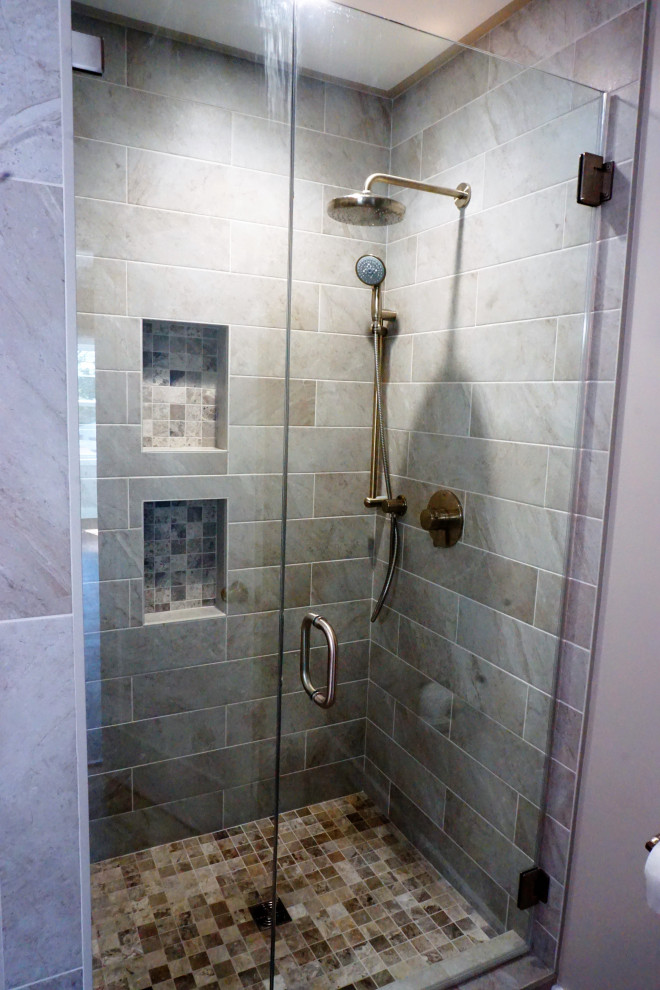 Mid-sized master gray tile and porcelain tile porcelain tile, gray floor and double-sink bathroom photo in Los Angeles with recessed-panel cabinets, white cabinets, a two-piece toilet, white walls, a drop-in sink, marble countertops, a hinged shower door, gray countertops, a niche and a built-in vanity