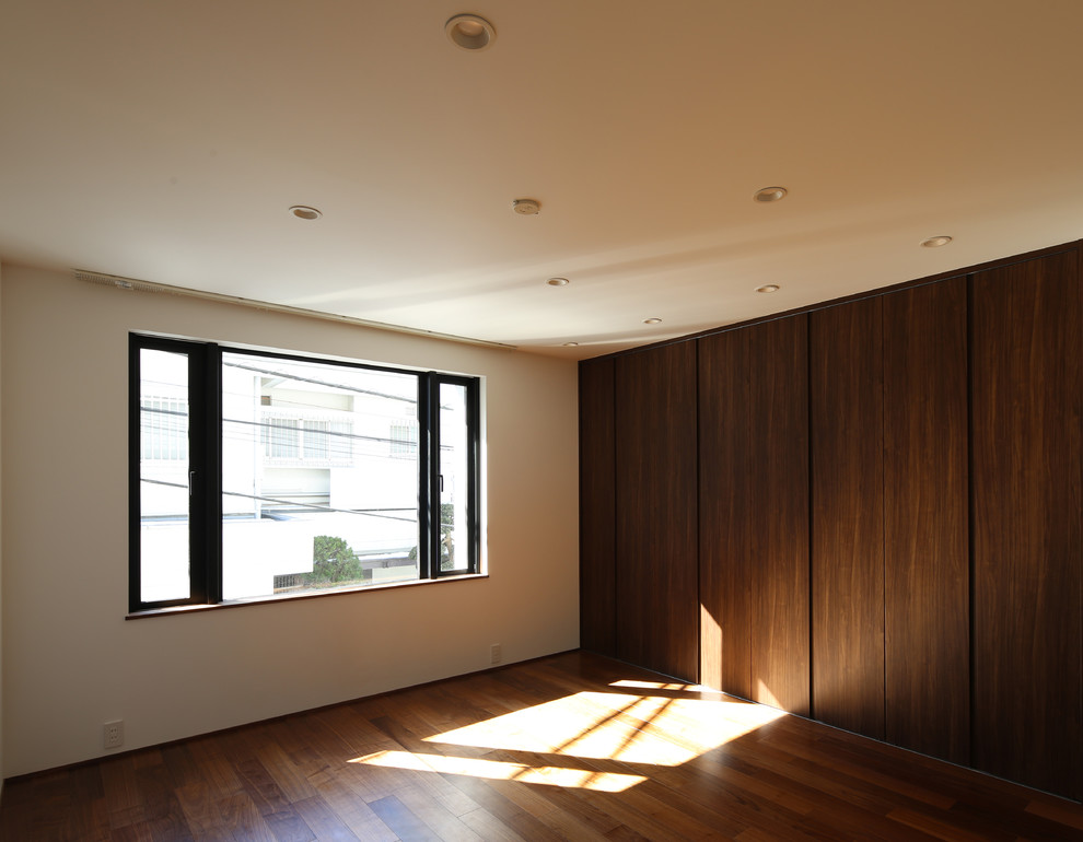 Idéer för mellanstora funkis huvudsovrum, med vita väggar, mörkt trägolv, en spiselkrans i gips och brunt golv