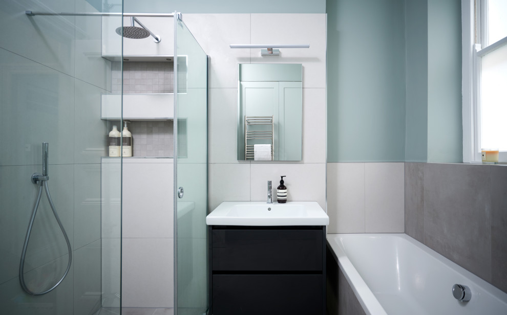 Photo of a mid-sized contemporary kids bathroom in Other with a drop-in tub, an open shower, beige tile, ceramic tile, blue walls, ceramic floors, beige floor, a wall-mount toilet and a drop-in sink.