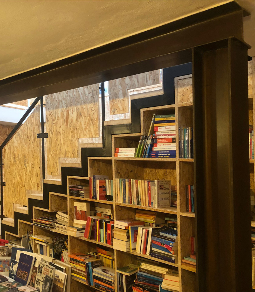 Immagine di un piccolo studio industriale con libreria, pareti beige, pavimento in compensato, nessun camino, scrivania incassata, pavimento beige e pareti in legno