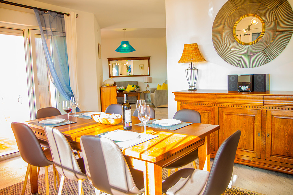 Ejemplo de comedor marinero de tamaño medio abierto con paredes beige, suelo de mármol y todas las chimeneas