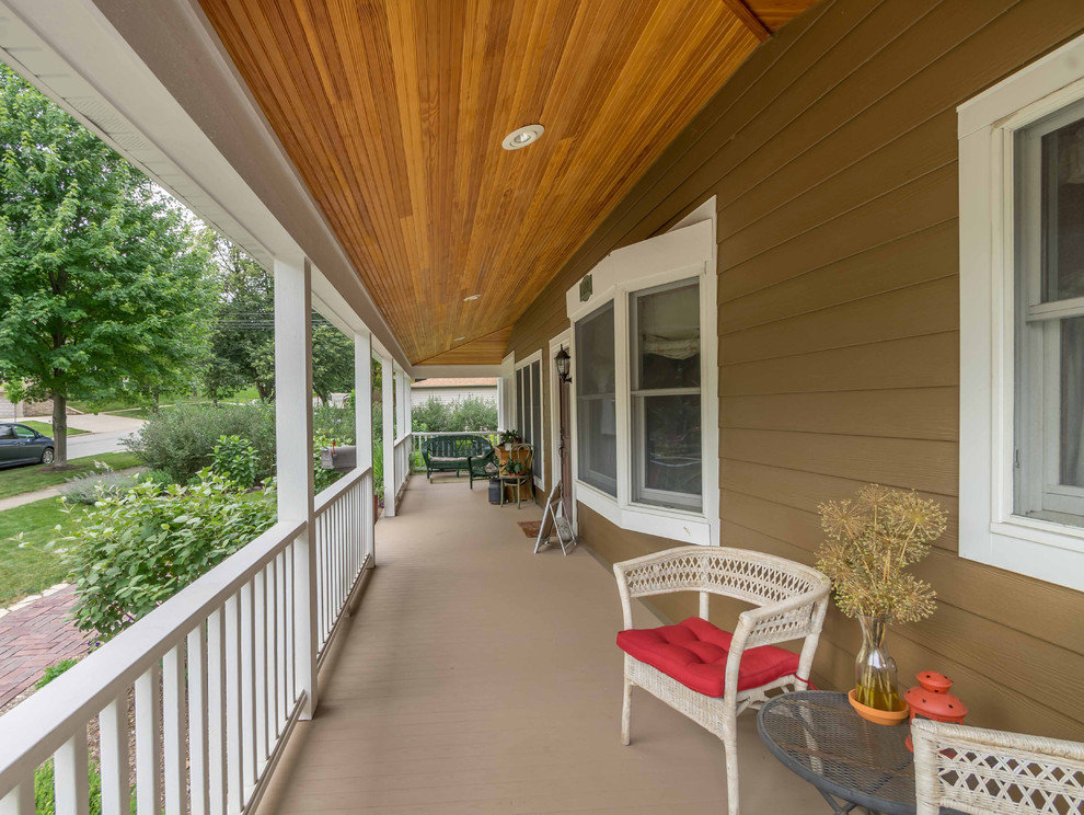 Photo of a mid-sized traditional side yard screened-in verandah in Chicago with brick pavers, a roof extension and wood railing.