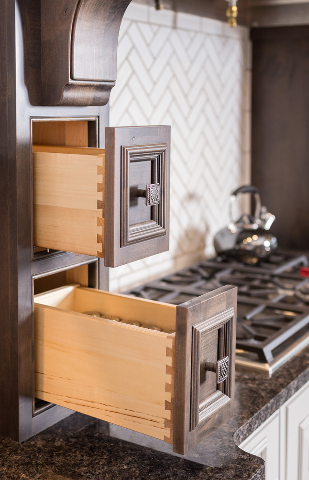 Example of a large transitional l-shaped gray floor open concept kitchen design with shaker cabinets, medium tone wood cabinets, granite countertops, white backsplash, subway tile backsplash, stainless steel appliances and an island