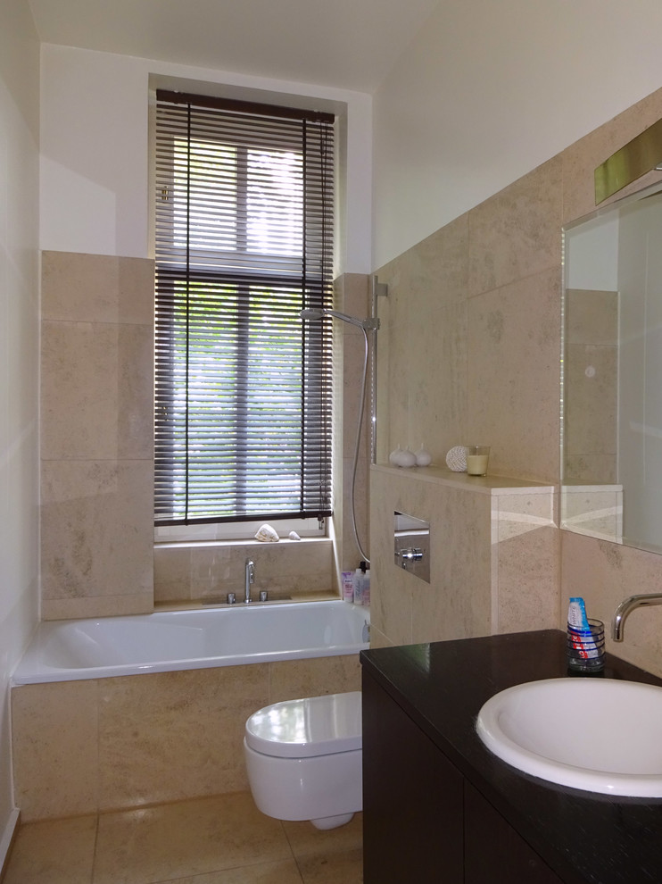 Duschbad With flächenbündigen Schrankfronten, dunklen Holzschränken, Einbaubadewanne, Wandtoilette, beigen Fliesen, Travertinfliesen, weißer Wandfarbe, Travertin, Einbauwaschbecken, Waschtisch aus Holz, beigem Boden and brauner Waschtischplatte in Berlin