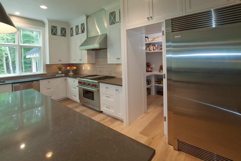 Eat-in kitchen - mid-sized transitional l-shaped light wood floor and beige floor eat-in kitchen idea with an undermount sink, shaker cabinets, white cabinets, solid surface countertops, multicolored backsplash, porcelain backsplash, stainless steel appliances and an island