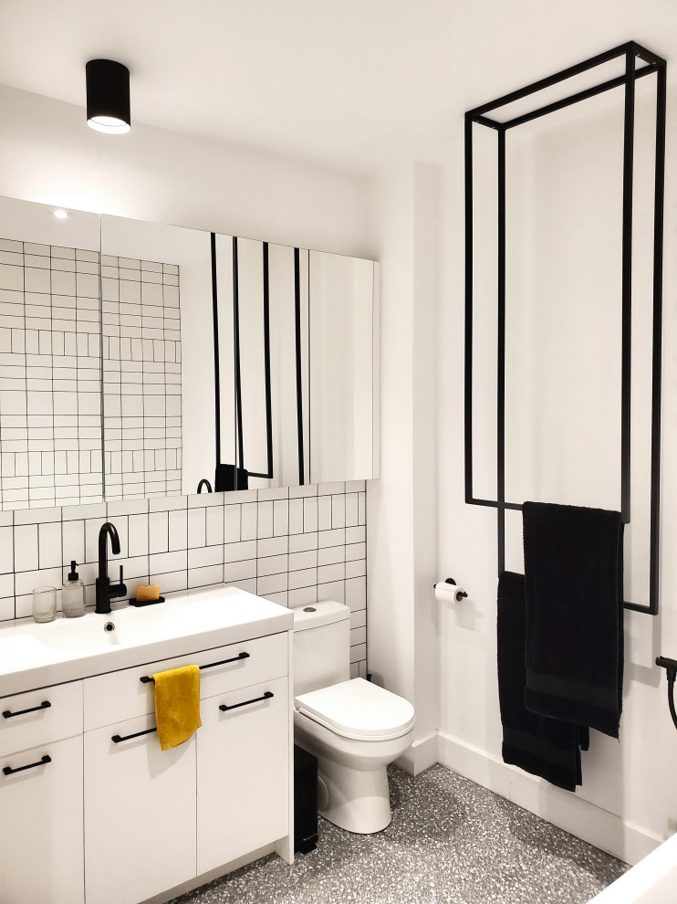 Mid-sized modern master bathroom in Montreal with flat-panel cabinets, white cabinets, a freestanding tub, a curbless shower, white tile, ceramic tile, white walls, terrazzo floors, solid surface benchtops, grey floor, an open shower, white benchtops, a single vanity and a built-in vanity.