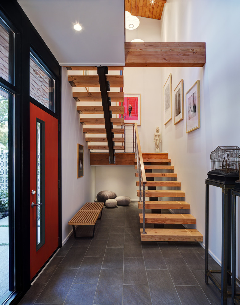 This is an example of a mid-sized contemporary entryway in Milwaukee with a red front door, white walls, a single front door, porcelain floors and grey floor.