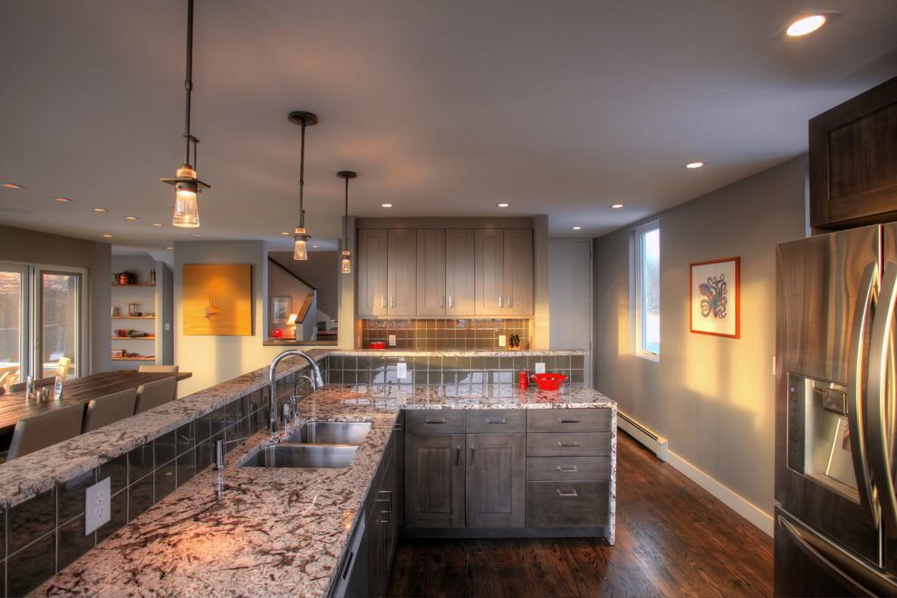 Large transitional u-shaped dark wood floor and brown floor eat-in kitchen photo in Boston with a double-bowl sink, shaker cabinets, gray cabinets, granite countertops, gray backsplash, glass tile backsplash, stainless steel appliances and an island