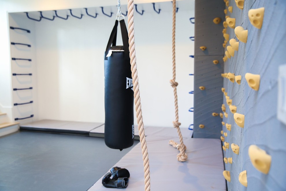Photo of a mid-sized modern home gym in New York with white walls.