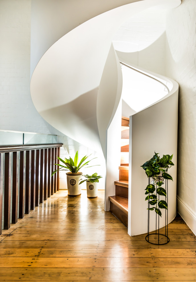 Идея дизайна: изогнутая деревянная лестница среднего размера в стиле модернизм с деревянными ступенями и перилами из смешанных материалов