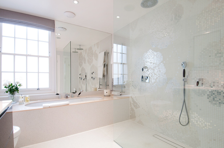 Photo of a large contemporary master bathroom in London with flat-panel cabinets, black cabinets, an undermount tub, an open shower, a wall-mount toilet, white tile, stone tile, white walls, an undermount sink, glass benchtops, white floor, an open shower, white benchtops, a double vanity and a floating vanity.