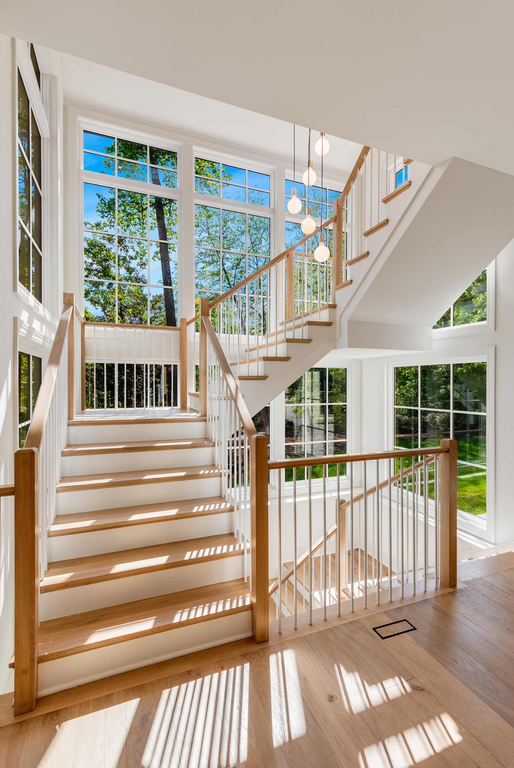 Project #152 | Three-Story White Oak Staircase with a Pendant Chandelier