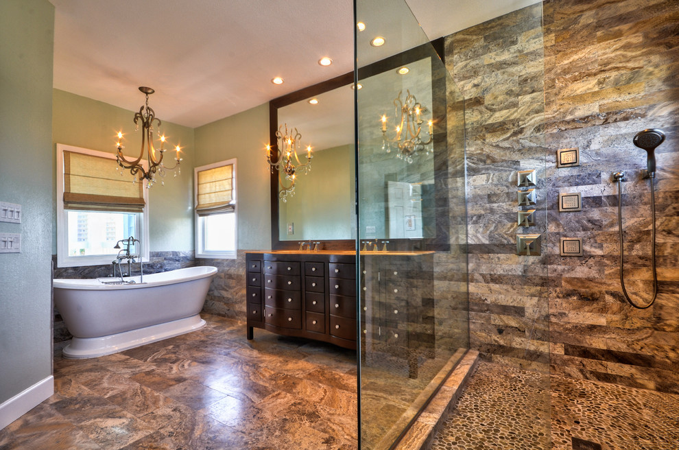 Design ideas for a large contemporary master bathroom in Tampa with furniture-like cabinets, dark wood cabinets, a freestanding tub, a corner shower, a two-piece toilet, multi-coloured tile, pebble tile, green walls, travertine floors, a console sink and granite benchtops.