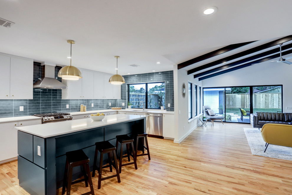 Свежая идея для дизайна: кухня в стиле ретро с плоскими фасадами, синими фасадами, столешницей из кварцевого агломерата, светлым паркетным полом и островом - отличное фото интерьера