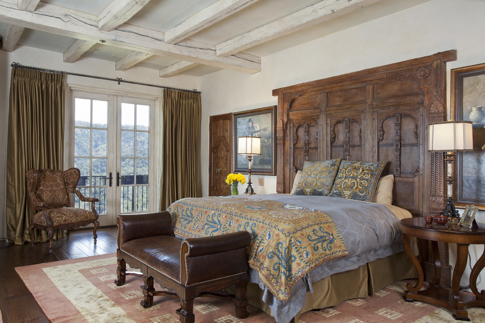 Mid-sized mediterranean master bedroom in San Francisco with beige walls, dark hardwood floors, no fireplace and brown floor.