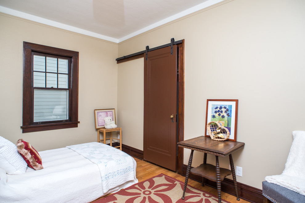 Inspiration for a small traditional guest bedroom in Detroit with yellow walls, light hardwood floors and no fireplace.