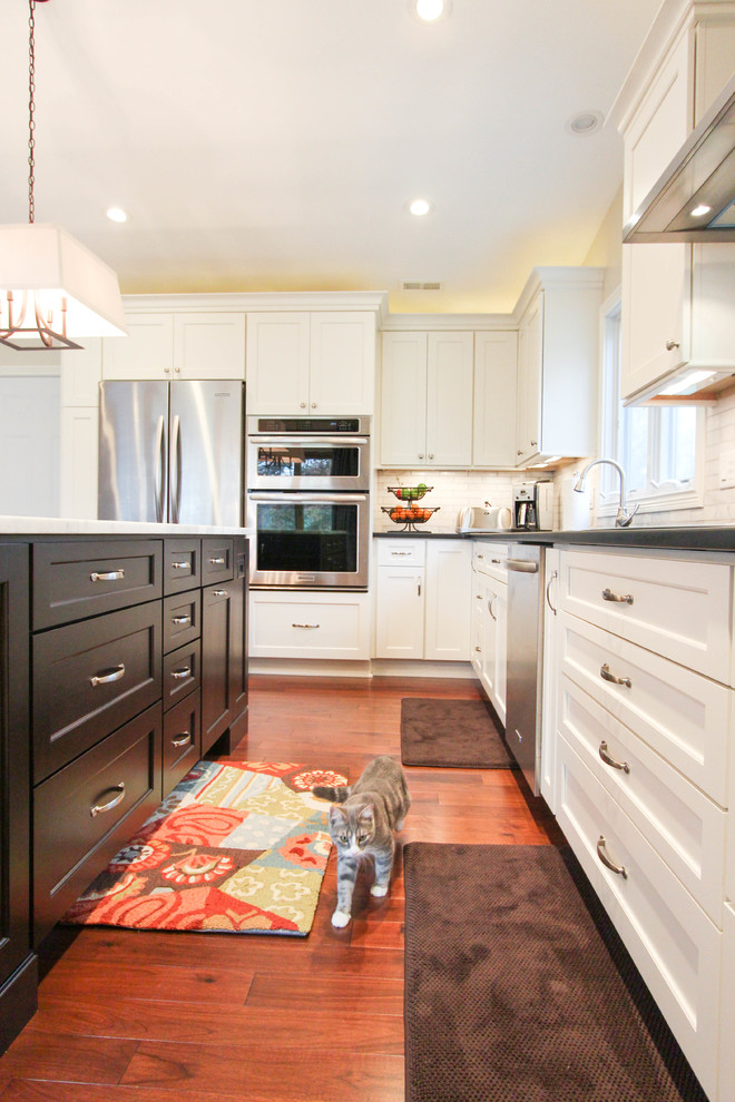 Mid-sized transitional l-shaped medium tone wood floor eat-in kitchen photo in Cincinnati with an undermount sink, recessed-panel cabinets, white cabinets, quartzite countertops, white backsplash, subway tile backsplash, stainless steel appliances and an island