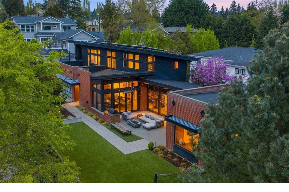 Großes, Zweistöckiges Industrial Einfamilienhaus mit Backsteinfassade, roter Fassadenfarbe, Pultdach, schwarzem Dach und Blechdach in Seattle
